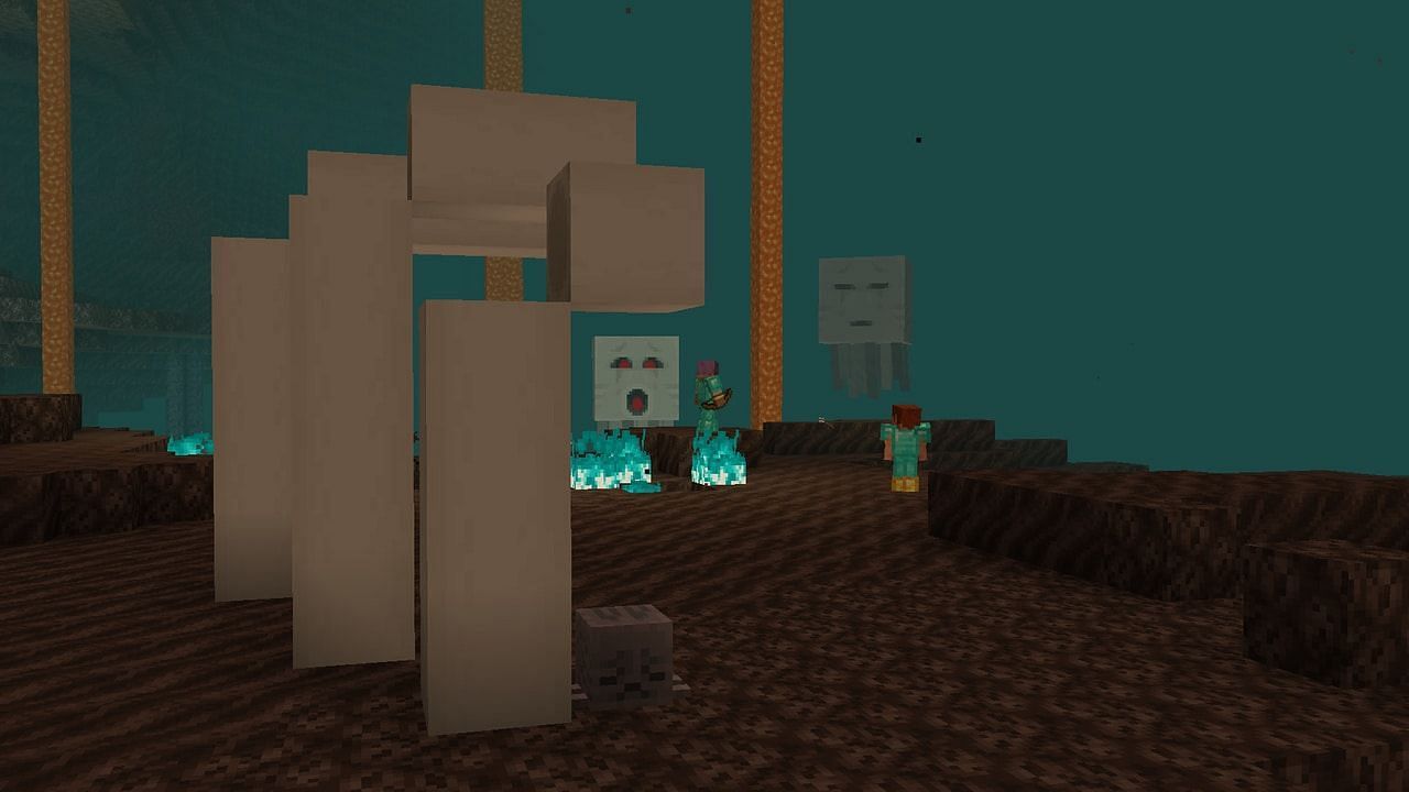 A Dried Ghast block underneath a Nether Fossil in a Soul Sand Valley. In the background, two players are battling angry Ghasts. (Image via Mojang).